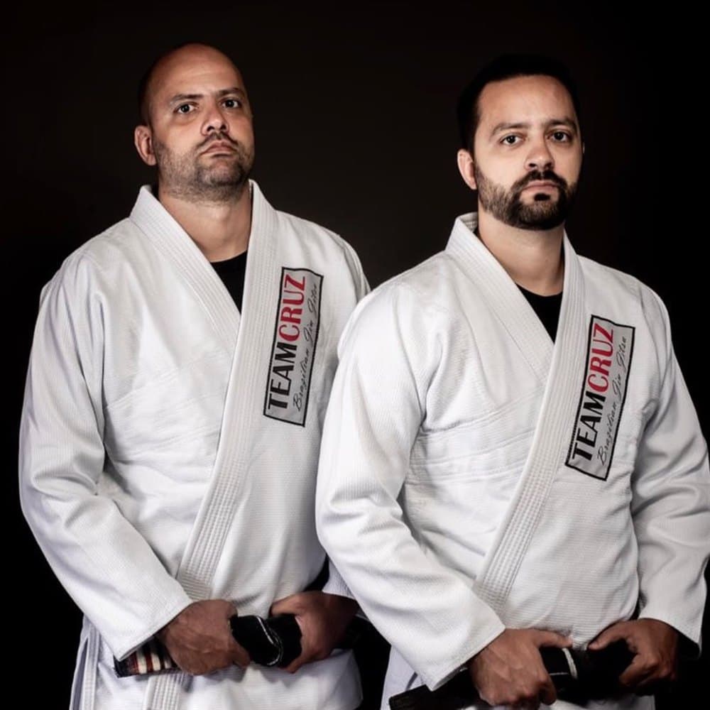 Jonathan e Andre Cruz, irmãos fundadores da Team Cruz, de kimono e faixa-preta
